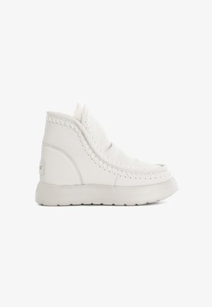 White leather ankle boots with a stitched design, textured surface, and soft lining; featuring a thick, rubber sole and slip-on style.