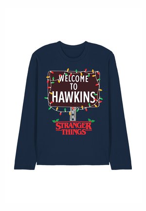 Navyblaues Langarmshirt mit einem braunen Schild, auf dem in weißer Schrift "WELCOME TO HAWKINS" steht, geschmückt mit bunten Weihnachtslichtern.