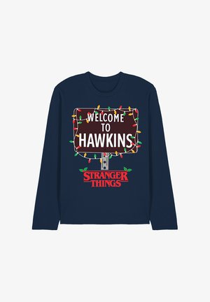 Navy long-sleeve shirt featuring a graphic of a brown sign with white text reading "WELCOME TO HAWKINS," adorned with colorful Christmas lights.