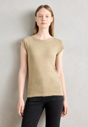 Beige short-sleeve t-shirt with a crew neck and fitted design. Smooth texture, ribbed neckline, paired with black jeans.