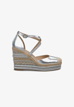 Silberne Keil-Espadrilles mit gekreuzten Knöchelriemen, mit Jute umwickelter Plattform und strukturierten metallischen Akzenten. Abgerundete Zehenpartie mit Kordeldetails.