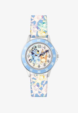 Montre pour enfants avec un boîtier en argent, lunette bleue et bracelet en silicone à motifs représentant des chiens de dessin animé dans des couleurs pastel. Cadran blanc avec des repères pour les heures et les minutes.