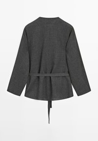 Giacca intrecciata grigio scuro con vestibilità ampia, maniche lunghe e una cintura in vita. Presenta una scollatura rotonda e un retro leggermente svasato.