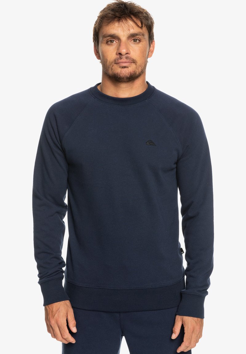 Navy blue sweatshirt in a soft, cotton blend. Features long sleeves, a crew neck, ribbed cuffs, and a small logo on the chest.