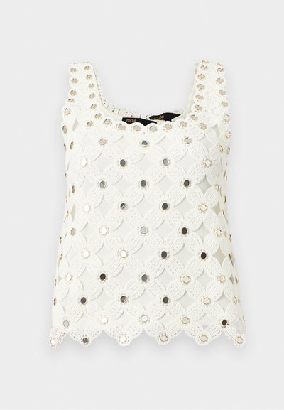 Haut blanc sans manches en crochet avec motif floral et accents circulaires métalliques répartis uniformément sur le tissu.