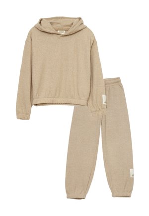 Set di abbigliamento da casa beige composto da un top corto con cappuccio e maniche elastiche e pantaloni alla caviglia abbinati con elastico, entrambi realizzati in un materiale morbido e textured.