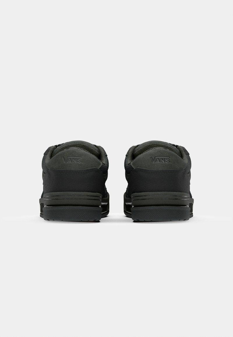 Czarne trampki Vans z gładką tekstylną cholewką, wyściełanym kołnierzem, płaską gumową podeszwą i detalem z logo na pięcie, widok z tyłu.