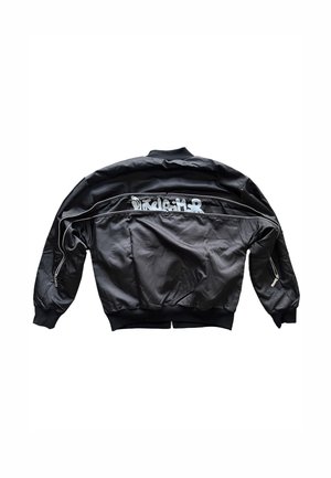 Giacca bomber nera in tessuto liscio, con colletto e polsini a coste, tasche con cerniera e scritta bianca sul retro.