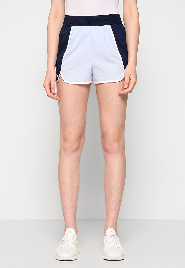 Shorts de sport bleu clair avec une ceinture et des panneaux latéraux bleu marine. Un piping blanc souligne les shorts. Fabriqués en tissu léger et lisse.