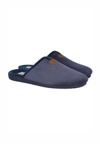 Zapatillas de tela azul marino con superficie texturizada, punteras redondeadas y una etiqueta de logo de cuero marrón. Diseño con parte trasera abierta para un uso fácil.