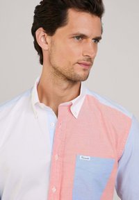 Overhemd met knopen in een kleurblokontwerp met roze, blauwe en witte secties, een borstzak en een klein logo-label.