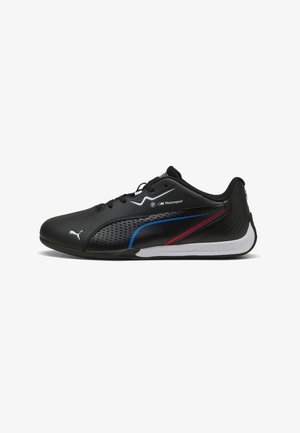 Schwarzer Puma Motorsport Sneaker mit schwarzen Schnürsenkeln, perforierter Seite, blauen und roten Akzentstreifen, weißer Sohle und Logos an der Seite und Zehenpartie.