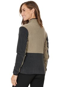 Veste en polaire avec un design bicolore en vert olive et gris charbon. Comprend des manches longues, un col haut et un tissu texturé.