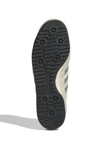 Black rubber sneaker sole featuring multi-directional tread, circular grip patterns, and a light gray midsole with purple accents.