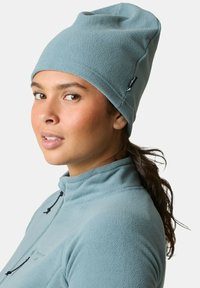 Vaaleansininen fleece-pipo, jossa on löysä muotoilu ja mustat yksityiskohdat. Yhdistettyä vastaavanlaiseen fleece-takkiin, jossa on korkea kaulus.