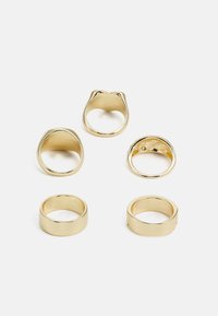 Conjunto de cinco anéis de ouro em formas variadas. Inclui estilos de bandas lisas e um design mais espesso e curvado com um acabamento polido.