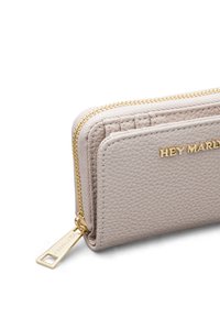 Portefeuille en cuir beige avec surface texturée, fermeture éclair dorée et détail gravé "HEY MARLY" sur le devant. Forme rectangulaire compacte.