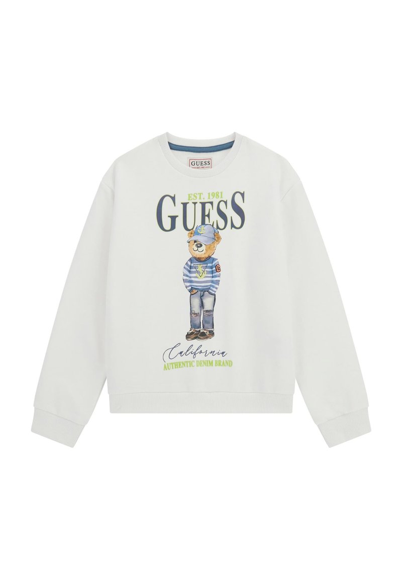 Felpa bianca con grafica di un orso vestito di blu e verde, con testo "GUESS EST. 1981". Polsini e orlo a costine. Vestibilità casual e rilassata.