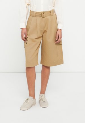 Shorts cargo beige avec plis et jambes larges, dotés de poches latérales, d'une ceinture avec une boucle rectangulaire et d'un ourlet retroussé.