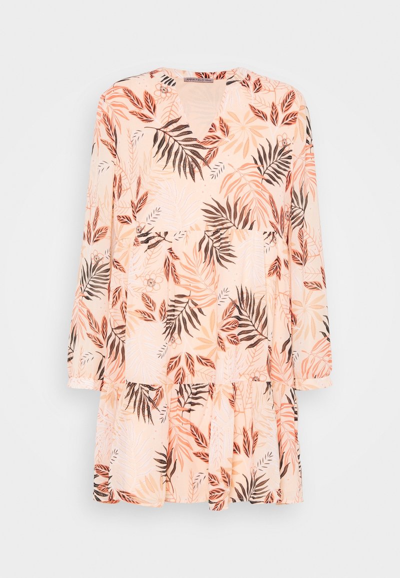 Robe pêche à manches longues avec col en V et jupe à volants, présentant un motif de feuilles tropicales en tons marron, orange et beige.