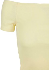 Gul ribbad off-shoulder topp med korta ärmar. Mjuk textur, figurnära design och ren söm längs halsringningen och ärmarna.