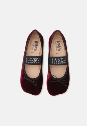 Paire de ballerines en velours bordeaux avec des bandes élastiques noires comportant des chiffres blancs et le logo Maison Margiela à l'intérieur.