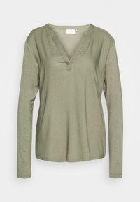 Oliwkowa koszula z długim rękawem z dekoltem w kształcie litery V, o miękkiej teksturze i luźnym kroju. Posiada detale przeszycia przy dekolcie i mankietach.