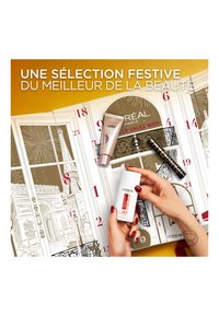 Produits de beauté L'Oréal affichés sur un fond doré ; comprend un correcteur, un écran solaire et un mascara avec un emballage élégant et des éléments de design.