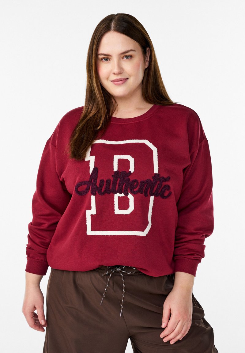 Bordeauxrotes Sweatshirt mit einem großen weißen "B" und dem eingestickten Schriftzug "Authentic" in dunklem Garn. Verfügt über eine lockere Passform und eine weiche Stoffstruktur.