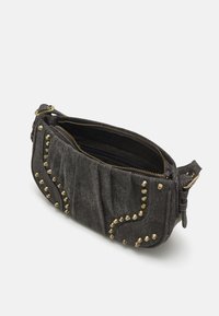 Zwarte denim handtas met gouden studs, ritssluiting en een gestructureerd oppervlak. Heeft een gebogen ontwerp met decoratieve stiksels en een zijschoen.