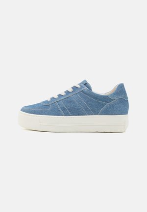 Denim-Sneaker mit einem blauen Canvas-Obermaterial, weißen Gummisohlen und hellgrauen Schnürsenkeln. Merkmale sind auffällige Nähte und ein runder Zehenbereich.