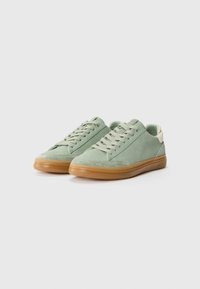Zapatillas verdes con una parte superior de tejido texturizado, acentos de ante y una suela de goma. Presentan cordones planos y un diseño minimalista.