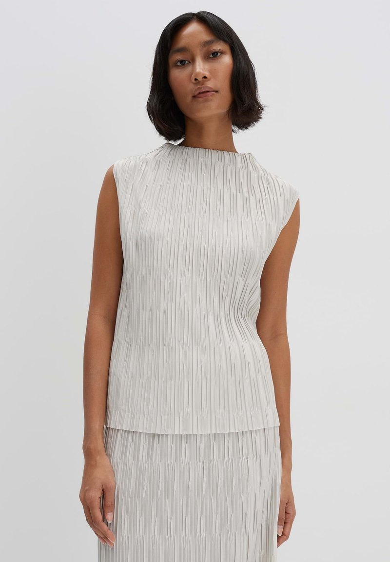Pleated sleeveless top in light gray fabric. Features a high neckline and flowing design. The texture has vertical lines creating movement.