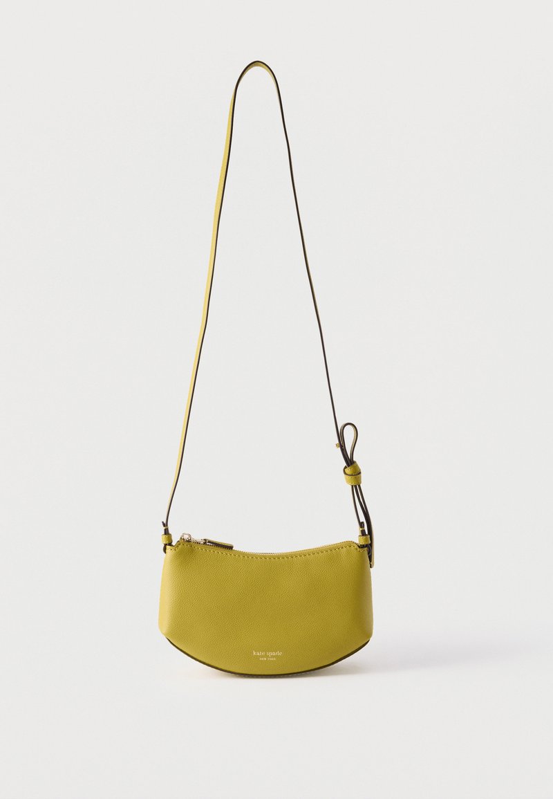 Μικρή κίτρινη δερμάτινη τσάντα ώμου με ρυθμιζόμενο λουρί και κλείσιμο με φερμουάρ, με το εμπορικό σήμα "kate spade new york" σε χρυσά γράμματα.