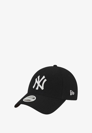 Black corduroy cap featuring a white embroidered "NY" logo, curved brim, and silver hardware on the front. Textured fabric adds depth.