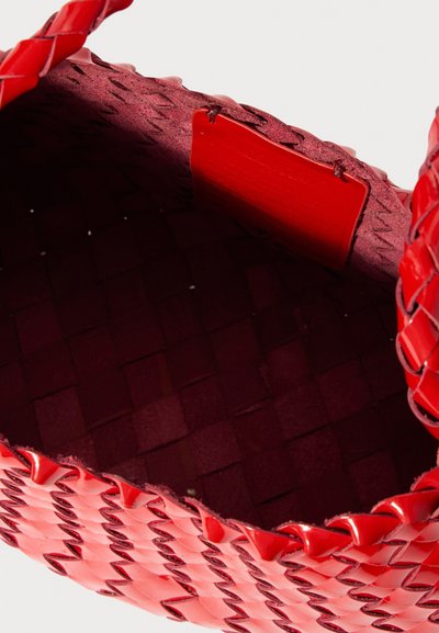 Borsa a tracolla rossa intrecciata con una finitura lucida, corpo testurizzato e una fodera interna liscia. Il colore dell'interno è una tonalità di rosso più scura.
