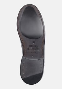 Suola in pelle nera con una finitura liscia, con borchie metalliche e la scritta in rilievo "HENRY STEVENS BERLIN." Cuciture distintive lungo il bordo.