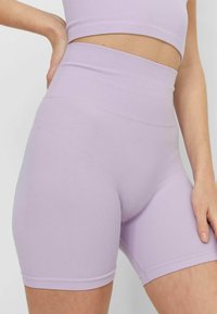 Shorts de tiro alto en color lavanda con textura suave, que presentan un acabado limpio en el dobladillo y un ajuste ceñido para confort y flexibilidad.
