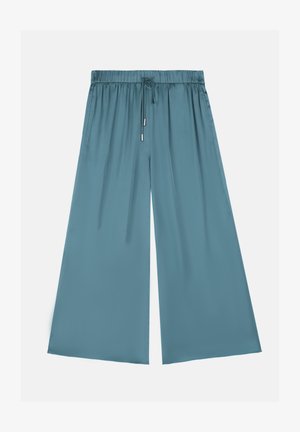 Calças largas em teal, feitas de tecido suave. Apresentam uma cintura elástica com cordão e dois bolsos laterais.