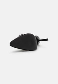 Zapato de tacón alto negro con puntera afilada, parte superior de tela texturizada, acabado elegante y un tacón de aguja delgado.