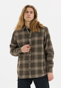 Bruin geruit overhemd met beige accenten, lange mouwen en een klassieke kraag. De stof lijkt zacht en iets gestructureerd.