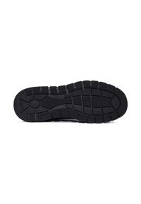 Semelle de chaussure en caoutchouc noir avec des rainures profondes, présentant une surface texturée et un motif circulaire au centre pour une meilleure adhérence et stabilité.