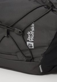 Grijze textuur rugzak met elastische bungee koord, voorzien van een wit logo en pootafdruk. Duurzaam materiaal met gestikte details.