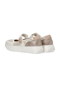 Zapatillas blancas y beige con patrones recortados, cinta de velcro, textura suave y una suela blanca gruesa. El panel trasero presenta un acento beige liso.