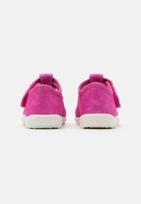 Pink suede sneakers with a soft texture, featuring a white rubber sole, two rear tabs, and no visible branding.