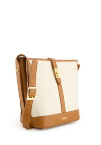 Biała skórzana torebka typu crossbody z brązowymi akcentami, z zapięciem na złotą klamrę i regulowanym paskiem. Teksturowany materiał i detal z logo na dole.