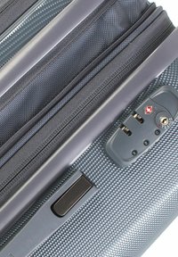 Grau hartschalen Koffer mit strukturierter Oberfläche, Reißverschlüssen und einem Zahlenkombinationsschloss. Verfügt über einen strapazierfähigen Griff und passende Stoffakzente.