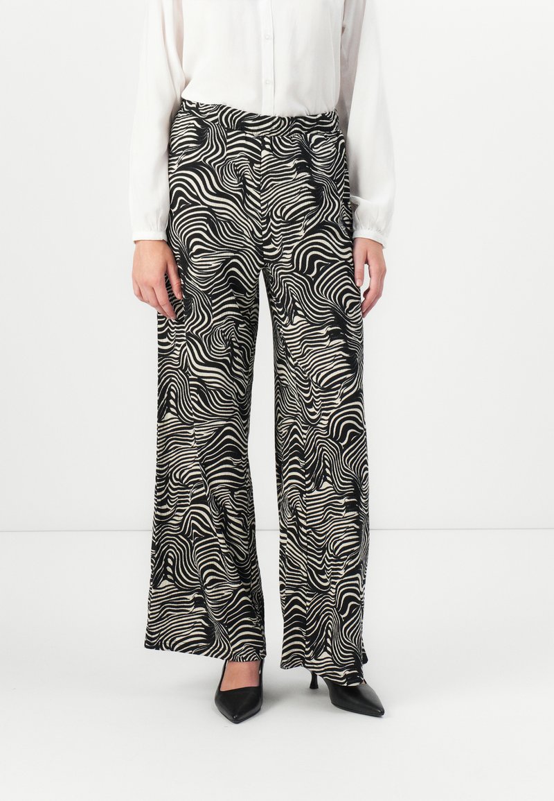 Wide-leg pants in black and white, featuring a wavy line pattern. Made from a lightweight fabric, with a relaxed fit and high waist.