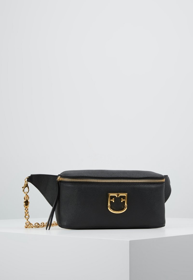 Sac banane en cuir noir avec fermeture éclair dorée et détail de chaîne, présentant un logo décoratif doré à l'avant.