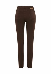 Jean skinny marron en denim extensible, avec poches arrière et petite étiquette de marque au-dessus de la ceinture. Texture lisse et coupe ajustée.